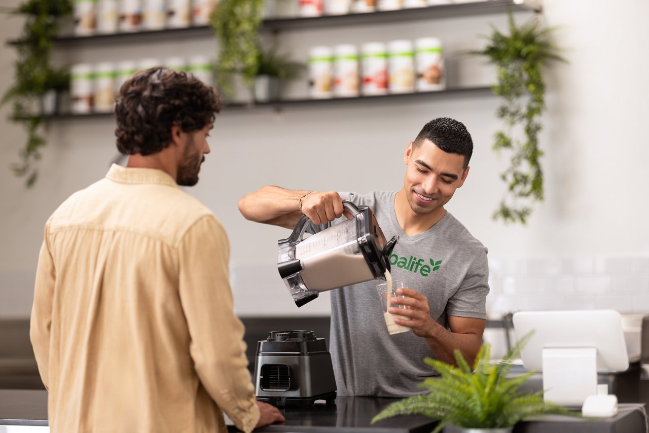 Man pouring a shake for another man.