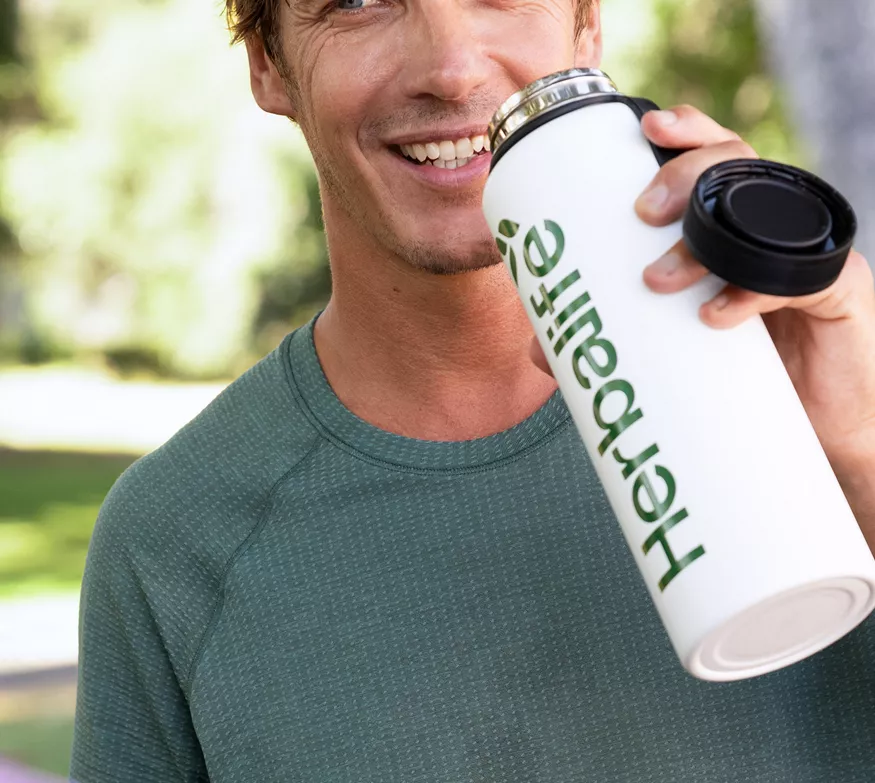 Man drinking protein shake park